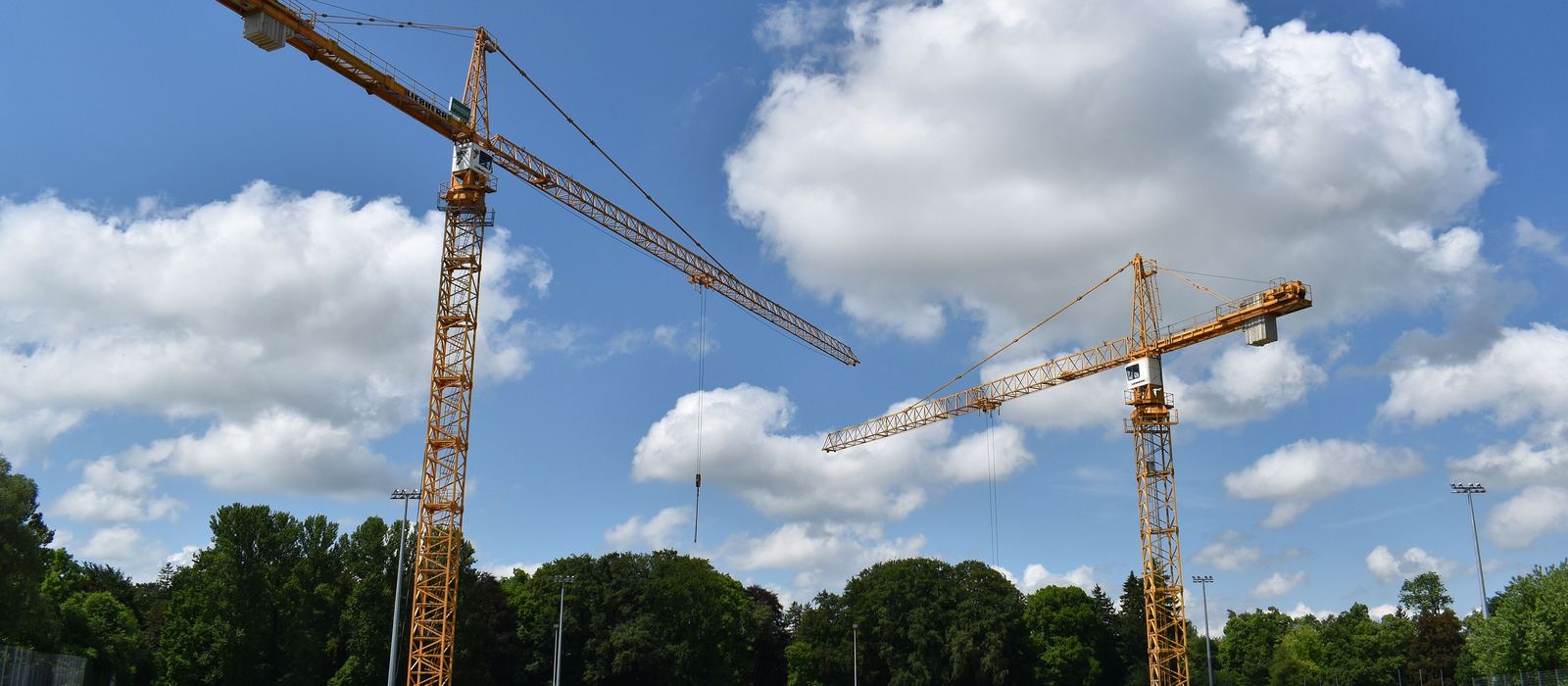 Zwei Baukräne über einer Baustelle